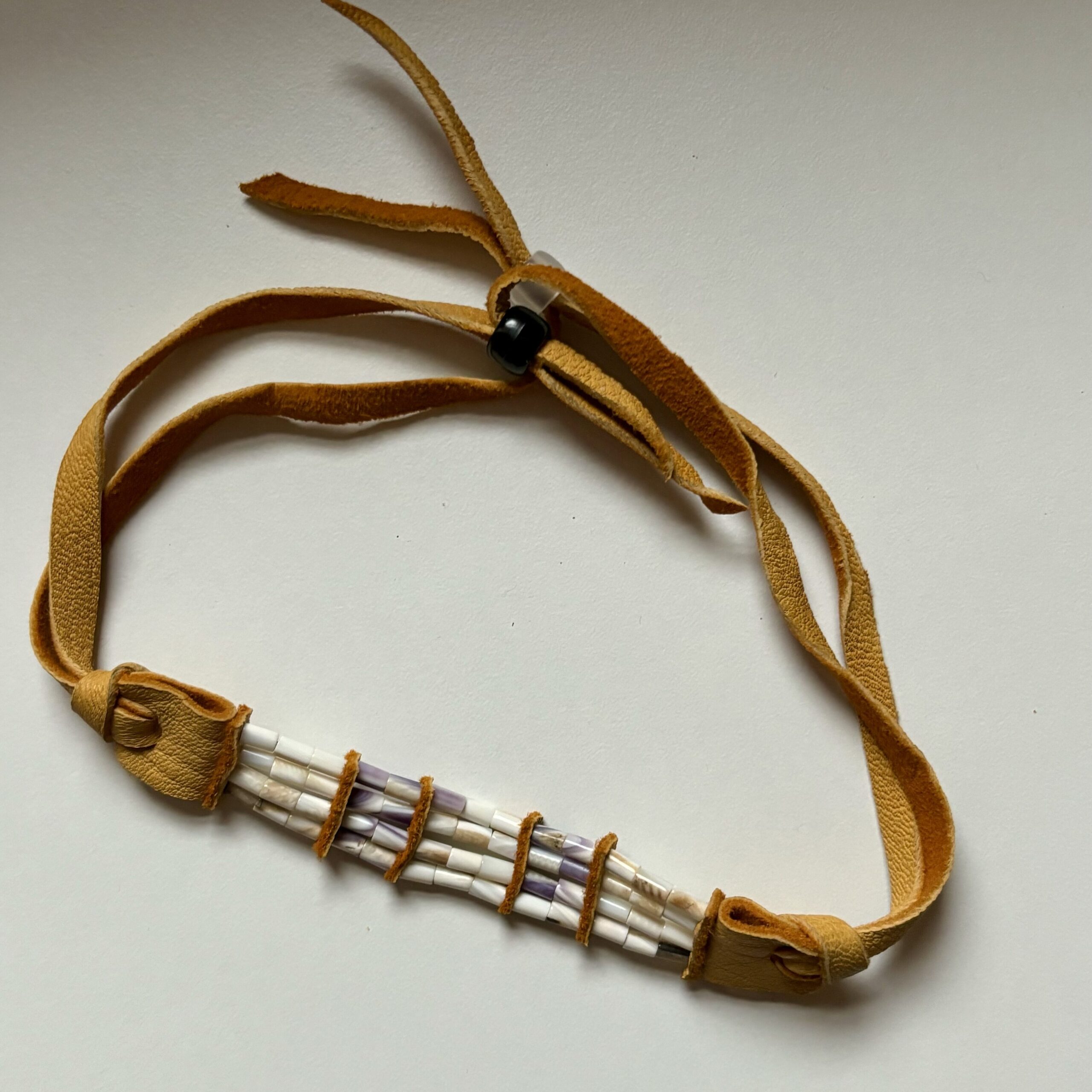 A two row wampum bracelet made with deer hide and quahog shell.